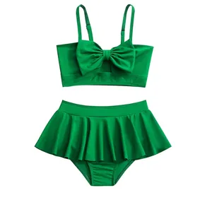 Two-piece bright green girl's swimsuit with oversized front bow and ruffled skirt