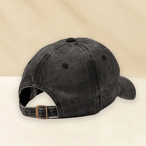 Detailansicht der Metallschnalle an einer verwaschenen schwarzen Denim-Baseballkappe