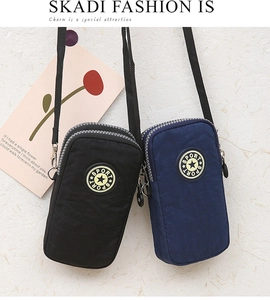 Detail of dual zipper multi-layer nylon crossbody phone bags in black and dark blue