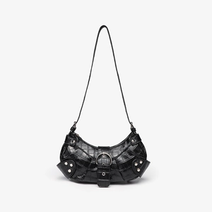Detail of black crocodile texture shoulder bag with silver studs and crescent shape