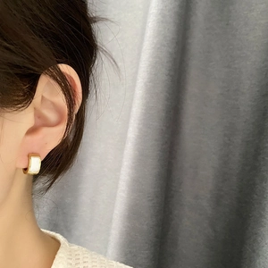 Elegant gold titanium steel hoop earrings with rectangular mother of pearl inlay on model