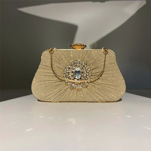 Detail of champagne gold evening clutch featuring rhinestone petal decor and chain