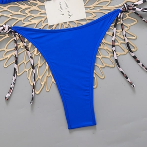 Close-up of blue bikini bottoms with leopard print side ties and elastic fabric detail