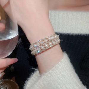 Close-up of multilayer pearl bracelet with shimmering diamonds on a female wrist
