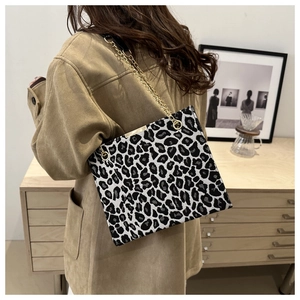 Detail shot of leopard print shoulder bag featuring golden chain strap and fabric texture