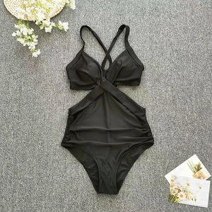 Flat lay of a black one-piece swimsuit featuring a criss-cross halter neck and waist cutouts