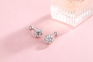 Macro view of crystal-encrusted silver ball stud earrings with screw-back design