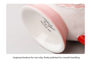 Close-up of the unglazed ceramic mug base with a Painted By Hand stamp and matte finish