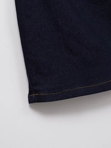 Detail shot of indigo denim dress showing high-quality stitching and fabric texture