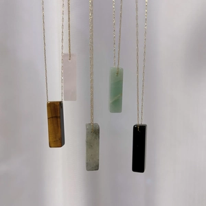 Vertical display of rectangular natural crystal pendant necklaces in various colors