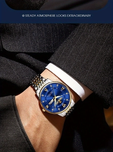 Detail of men's business watch with blue sunray dial and gold Roman numerals on wrist