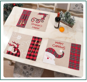 Flat lay of linen Christmas placemats with Santa and Reindeer on a marble tabletop
