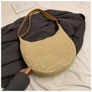Detail of hobo straw shoulder bag with beige woven texture and brown smooth strap