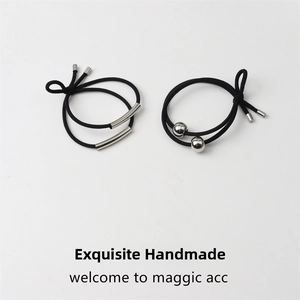 Close-up of minimalist black elastic hair bands with silver metal tubes and bead accents
