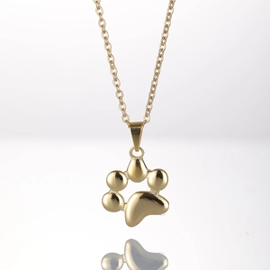 Macro shot of 18K gold plated stainless steel cat paw pendant necklace with mirror reflection