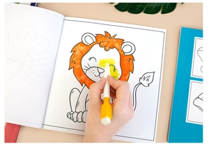 Detail shot of a child coloring a cartoon lion in a creative drawing book with a pen