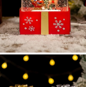 Detail of red Christmas snow globe base with power cable and snowflake gift box design