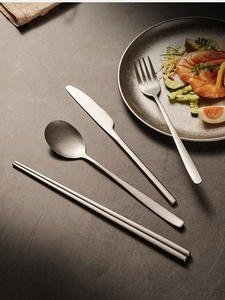 Modern snowflake grey stainless steel cutlery set displayed on a textured tabletop
