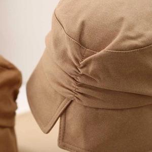 Close-up of side pleats and fine stitching on brown cotton sun hat fabric detail