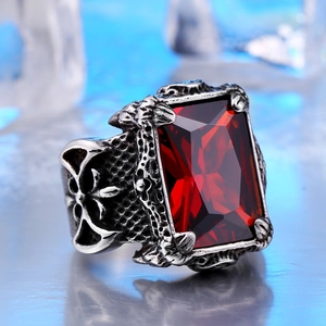 Detailed close-up of a vintage steel ring with a large red ruby and cross carvings