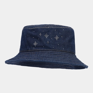 Close-up of sparkling rhinestone star patterns on a dark blue denim fisherman bucket hat