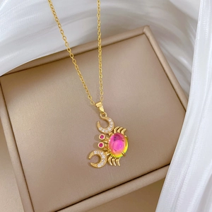 Close-up of gold crab pendant with colorful iridescent crystal and sparkling zircon stones