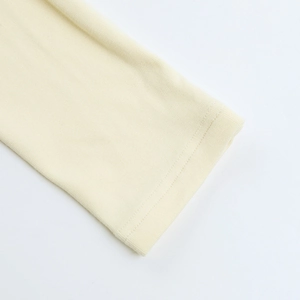 Gros plan détaillé des poignets côtelés avec dentelle sur t-shirt crème à manches longues
