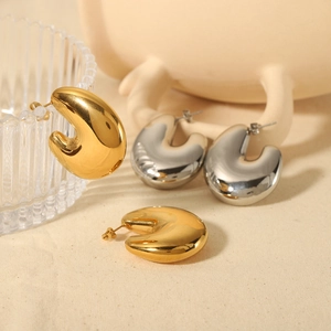 18K gold and silver hollow bubble hoop earrings displayed on elegant beige fabric
