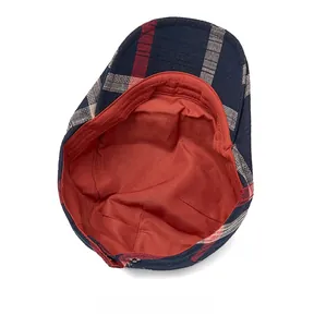 Detailed interior view showing red lining and plaid fabric of the British newsboy cap