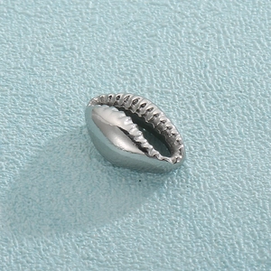 Macro shot of silver scallop-shaped stainless steel pendant with textured edges