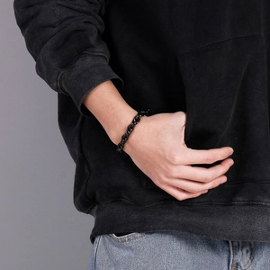 Close-up of a matte black punk style titanium steel chain bracelet on a male wrist