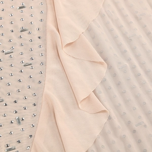 Detail of ruffle mesh fabric with sparkling silver rhinestones and crystal beads