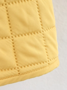 Gros plan sur le tissu matelassé jaune vif avec coutures carrées et bordure renforcée