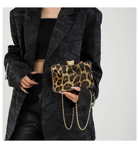 Detail of elegant leopard print square clutch bag with golden chain and clasp for women
