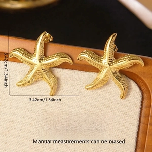 Detailed view of golden starfish earrings in stainless steel with textured finish