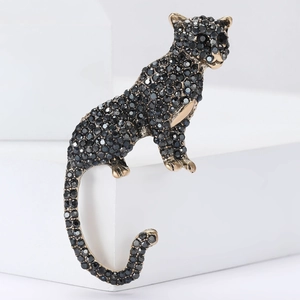 Retro panther brooch in gold-toned alloy with black rhinestones on a white stand