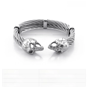 Macro detail of gothic punk double skull stainless steel cable bangle bracelet