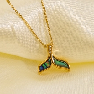 Macro shot of dolphin tail necklace featuring iridescent shell inlay and three zircons