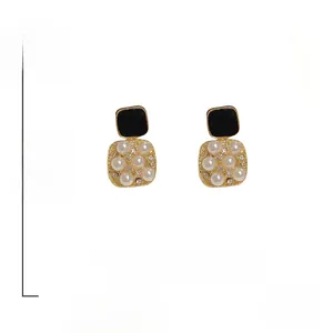 Detailed view of vintage square stud earrings featuring pearls, crystals, and black enamel inlay