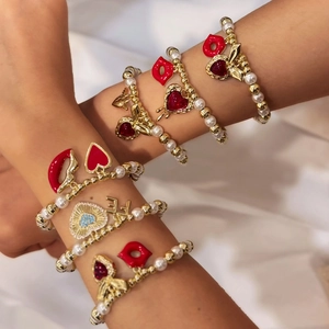Bracelets en perles dorées 18 carats avec breloques cœur et lèvres rouges sur poignets