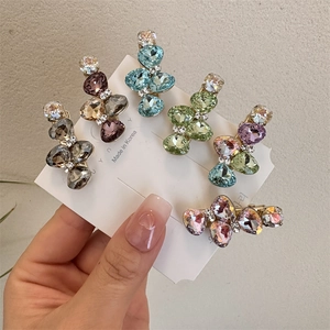 Détail de cinq barrettes nœuds en cristal de couleurs variées sur carte de vente