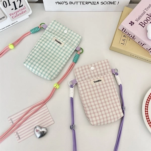 Close-up of checkered canvas phone pouches with woven straps and adjustable buckles