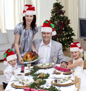 Family in festive setting wearing red and green striped Christmas hats for decoration