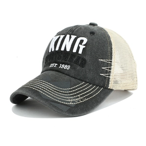 Dettaglio macro del ricamo 3D KING e del tessuto grigio lavato del cappellino baseball mesh