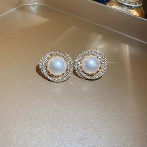 Gros plan détaillé de boucles d'oreilles vintage en or avec perles et zircons brillants