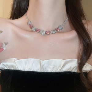 Detail of silver choker necklace featuring pink square gems and floral zircon elements