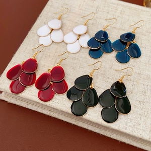 Macro view of multi-layered water drop tassel earrings in white and deep blue enamel