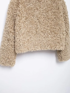 Close-up of khaki teddy fleece texture on jacket hem and cuffs with soft fuzzy fabric