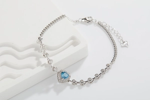 Detailed view of S925 silver bracelet featuring blue heart topaz and zirconia clusters