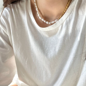 Baroque pearl and gold twisted rope chain asymmetrical necklace worn by a model